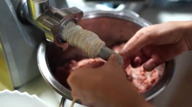 Woman corrects the gut on the nozzle for a meat grinder. High quality 4k footage