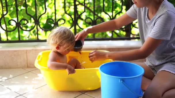 Mamá Riega Una Niña Sentada Una Bañera Plástico Terraza Desde — Vídeo de stock