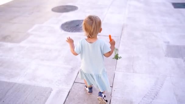 Little Girl Carrot Her Hand Walks Street High Quality Fullhd — Stok Video