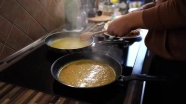 Man stirs boiling orange zest in butter in pans with a spatula. High quality 4k footage