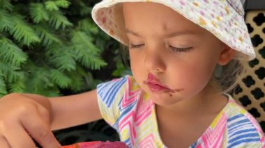 Little girl eats popsicles in a waffle cone with a spoon. High quality 4k footage