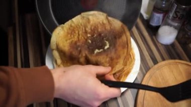 Cook stacks ruddy pancakes on a plate. High quality 4k footage