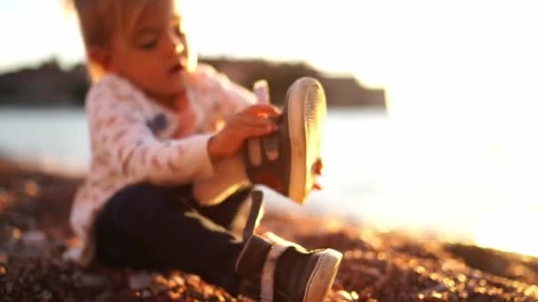 Little Girl Puts Sneakers Her Feet While Sitting Seashore High — Video