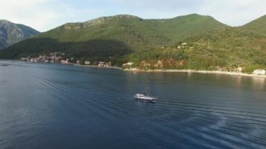 Yelkenli yat yeşil dağların arka planına karşı denizde yüzüyor. Yüksek kalite 4k görüntü