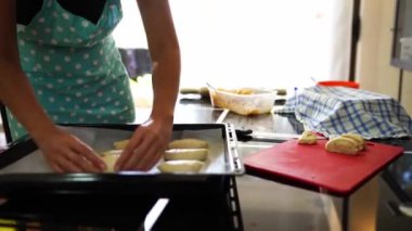 Woman stacks buns on a baking sheet and sculpts dough. High quality 4k footage