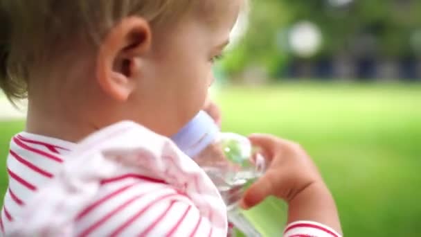 小さな子供は 飲料バルブを備えたボトルから水を飲みます 高品質4K映像 — ストック動画
