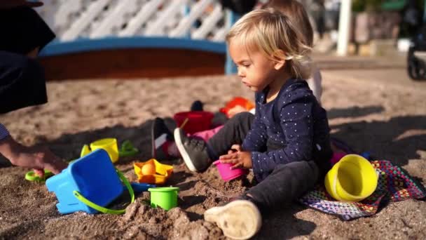 Mom Puts Plastic Molds Buckets Sand Front Little Girls High — Vídeo de stock