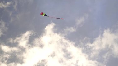 Rainbow kite flying in the cloudy sky. High quality 4k footage