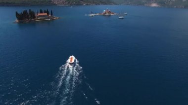 Boat sails to the islands of St. George and Gospa od Skrpjela. Montenegro. High quality 4k footage