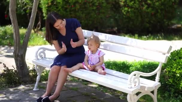 Mom Claps Her Hands Little Girl Sitting Her Park Bench — Stok video