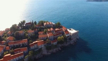 Kale duvarlarıyla çevrili eski binaları olan Sveti Stefan adası. Drone. Yüksek kalite 4k görüntü
