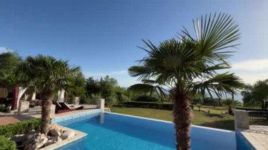 Sun loungers stand by the pool with turquoise water. High quality 4k footage