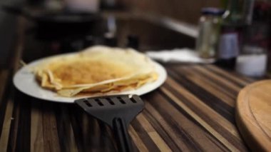 Stack of pancakes is steaming on a plate on a table by the stove. High quality 4k footage