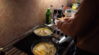 Cook puts rolled pancakes in orange sauce in a pan and pours over them with a spoon. High quality 4k footage