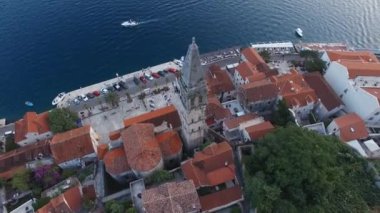 High bell tower of the Church of St. Nicholas in Perast overlooking the sea. Drone. High quality 4k footage