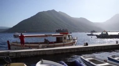 Pleasure boat moored at the Perast pier overlooking the island of St. George. Montenegro. High quality FullHD footage