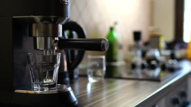 Man puts a glass on the stand of the coffee machine and turns it on. High quality 4k footage