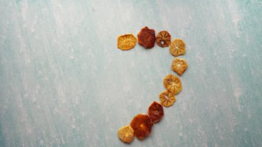 Woman hand lays out a heart of dried fruits on a blue table. Time lapse. High quality 4k footage