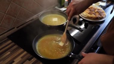 Man melts butter in a hot frying pan while stirring with a wooden spatula. High quality 4k footage