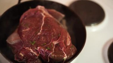 Roast beef with rosemary is fried in a pan and steam comes out. High quality 4k footage