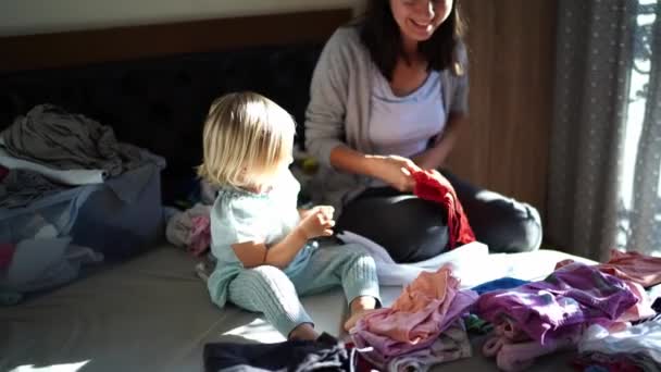 Gülümseyen Anne Kızının Yanında Otururken Temiz Çarşafları Katlar Yüksek Kalite — Stok video