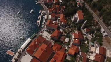 Sahildeki yeşil ağaçların arasında eski Perast evlerinin çatıları. Yüksek kalite 4k görüntü
