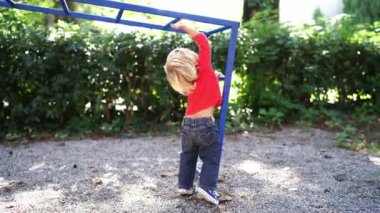 Little girl trying to climb stairs in the playground. High quality 4k footage