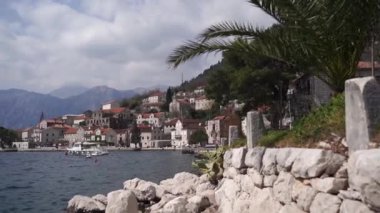 Rocky coast of Perast with old houses and moored boats. Montenegro. High quality FullHD footage