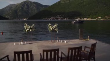 Çiçek buketlerinin yarı kemeri iskelede, sandalyelerin önünde duruyor. Yüksek kaliteli FullHD görüntüler