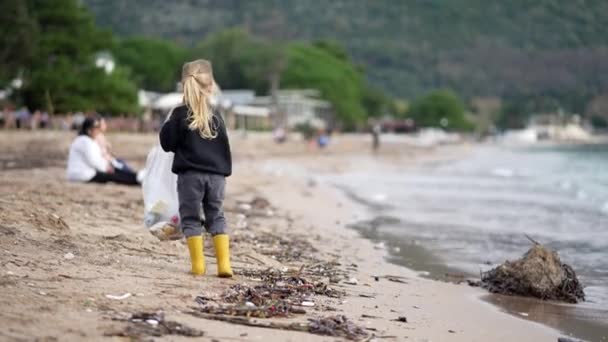 Маленькая Девочка Волонтер Собирает Мусор Берегу Моря Высококачественные Кадры — стоковое видео