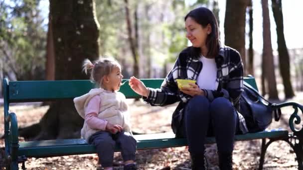 Anya Zabkását Etet Egy Kanálból Ami Egy Padon Parkban Kiváló — Stock videók