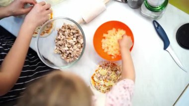 Anne ve küçük kızı pizzanın üzerine sos serperler. Yüksek kalite 4k görüntü