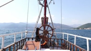 Bir geminin güvertesi deniz boyunca dağlık bir kıyıya doğru hareket ediyor. Yüksek kalite 4k görüntü