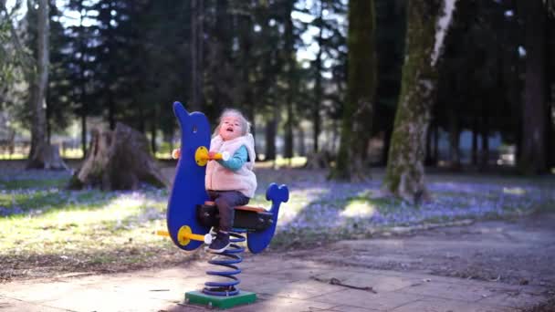Petite Fille Balance Sur Une Balançoire Ressort Tenant Les Poignées — Video