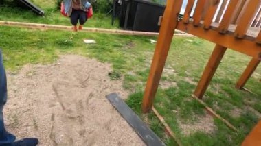 Babam parkta salıncakta sallanan küçük bir kızı sallıyor. Yüksek kalite 4k görüntü