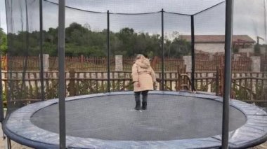 Küçük kız parkta trambolinde koşup zıplıyor. Yüksek kalite 4k görüntü