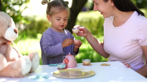 Anne Küçük Kız Bahçedeki Masada Oyuncak Fincanlar Çaydanlıkla Çay Partisi — Stok video