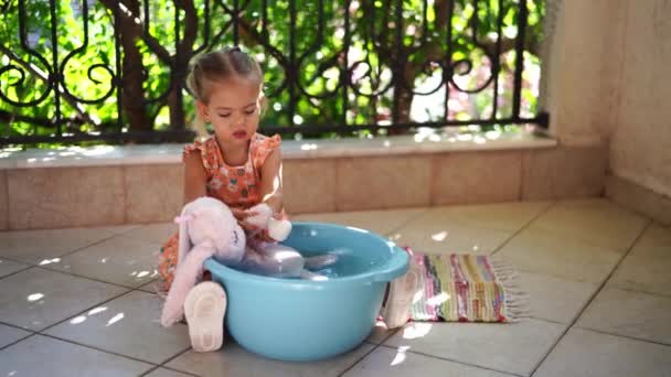Liten Flicka Tvättar Med Tvål Plysch Hare Skål Balkongen Högkvalitativ — Stockvideo