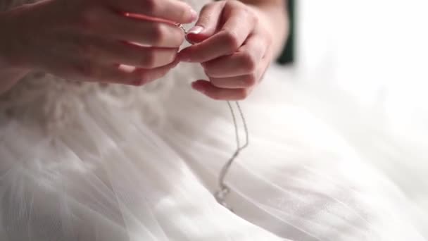 Bruid Een Witte Jurk Maakt Ketting Los Met Een Hanger — Stockvideo