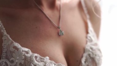 Beyaz elbiseli bir gelinin boynunda elmas bir kolye. Kırpılmış. Yüksek kaliteli FullHD görüntüler