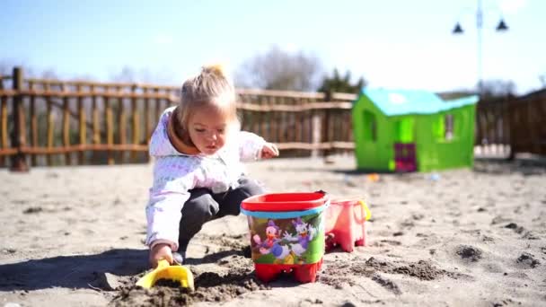 Küçük Kız Bir Kürekle Kumu Kazıyor Oyun Parkındaki Oyuncak Kovaya — Stok video