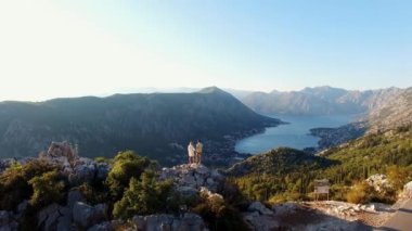 Erkek ve kadın bir kayanın üzerinde duruyor ve Kotor Körfezi 'ne bakıyor. Drone. Yüksek kalite 4k görüntü