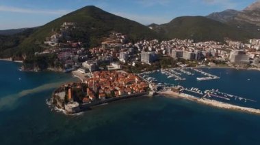 Dağların arkasında kırmızı çatıları olan Budva 'nın eski taş evleri. Karadağ. Yüksek kalite 4k görüntü