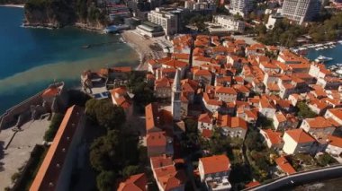 Budva 'da deniz kıyısındaki eski taş evlerin kırmızı çatıları. Karadağ. Yüksek kalite 4k görüntü