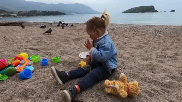 Bambina Siede Sulla Spiaggia Scolpisce Figure Sabbia Filmati Alta Qualità — Video Stock