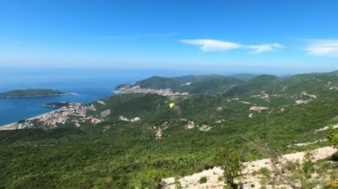 Paraşütçü dağlardaki yeşil ağaçların üzerinden uçar. Yüksek kalite 4k görüntü