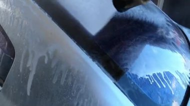 Arka camı ve bir arabanın bagajını sabunlu bir solüsyonla yıkamak. Yüksek kalite 4k görüntü