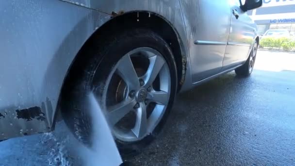 Het Achterwiel Van Een Auto Wassen Een Wasstraat Met Een — Stockvideo