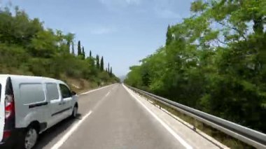 Arabalar yüksek bir dağ sırasına bakan bir otoyolda sürerler. Yüksek kalite 4k görüntü