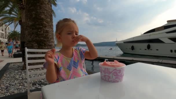 Mała Dziewczynka Lody Łyżeczką Siedząc Przy Stole Molo Wysokiej Jakości — Wideo stockowe
